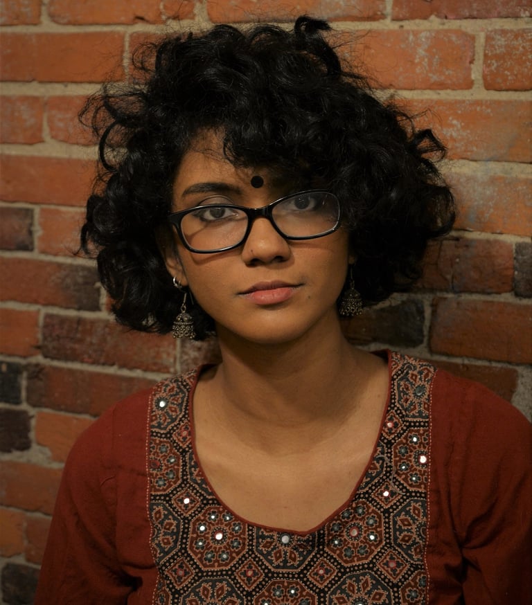 An Image of Athira in front of a brick wall