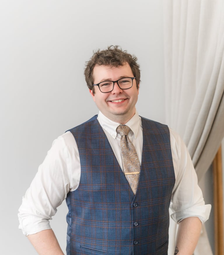 Picture of Rocco Catrone in white button up shirt and blue vest. 