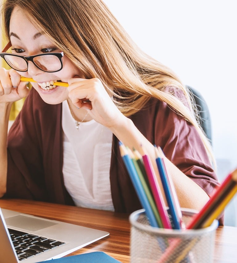 a woman sitting at a desk with a pencil and pencils