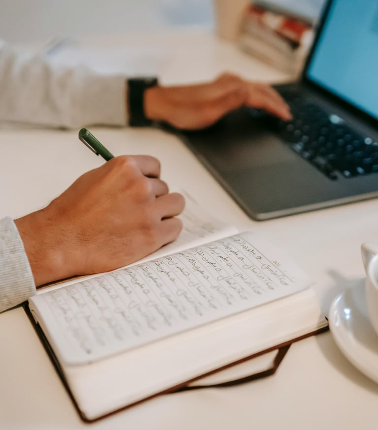a person sitting at a desk with a pen and a cup of coffee