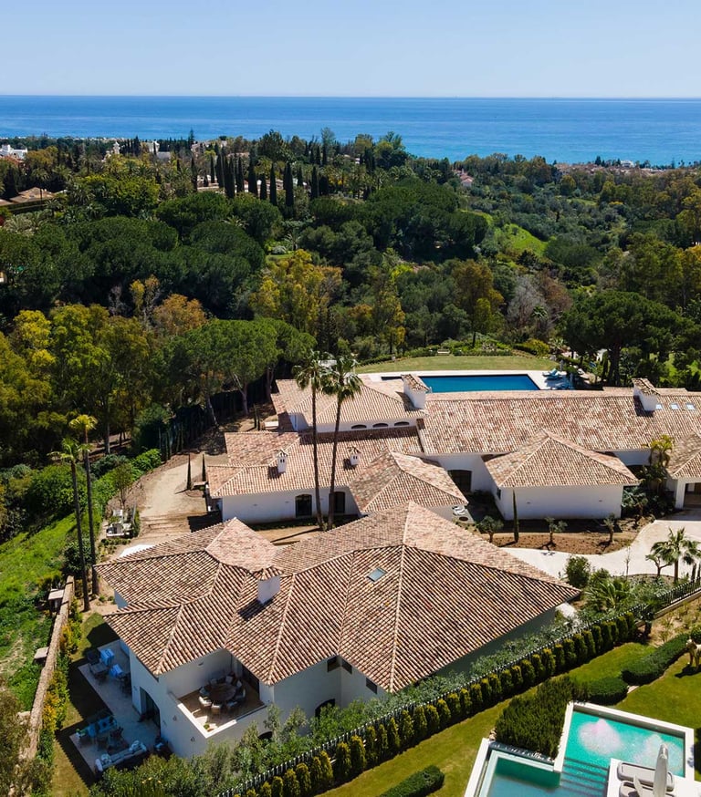 Aerial view of estate with pool, tennis court and sea backdrop