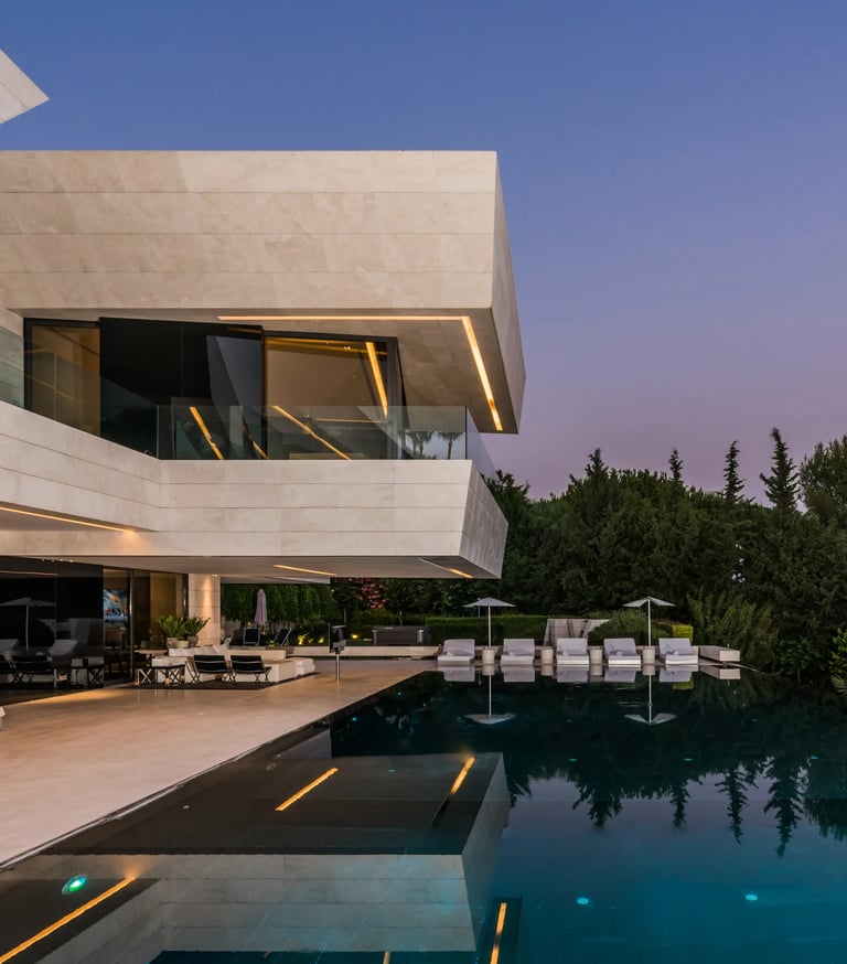Dusk terrace with illuminated pool and glass façade