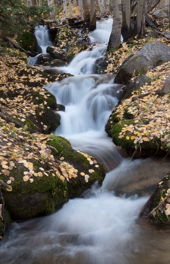 waterfall with flowing water and golden leaves on the banks of the river. relaxing and peaceful