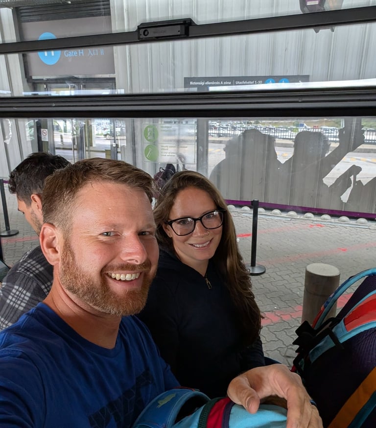Moose and Bugs taking a selfie while waiting inside an airport shuttle bus at Gate H.