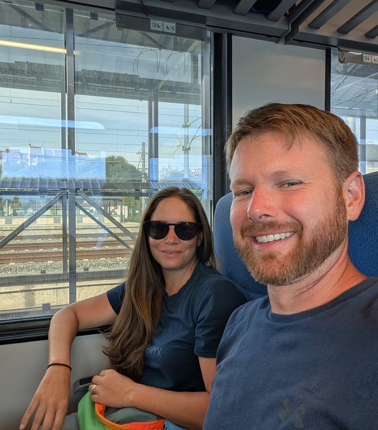 Moose and Bugs traveling together on a modern commuter train with scenic window views.