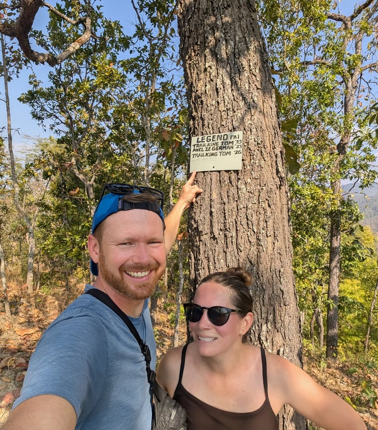 Don and Samantha standing in front of a small sign in Huai Na Dang Natiopnal Park, Thailand