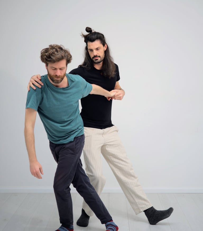 practitioner holding client at shoulder and arm as they move through the room