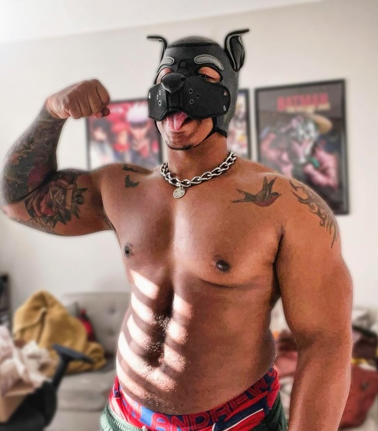 A man poses in a pup mask.