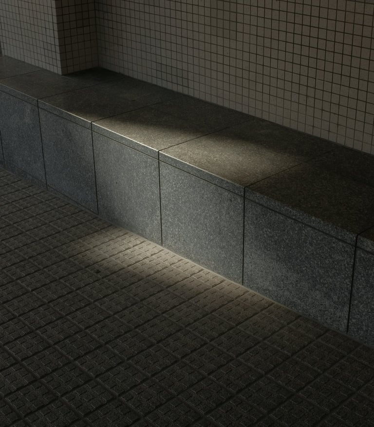 Sunlight casting shadows on a concrete tiled seating area and wall.