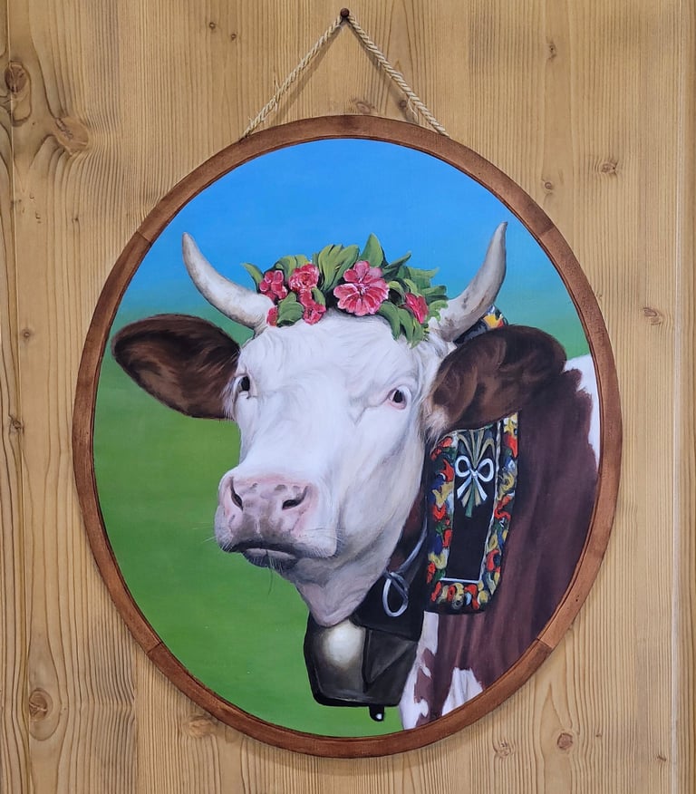Une tête de vache Montbéliarde ornée de fleurs peinte en trompe-l'oeil dans son faux médaillon