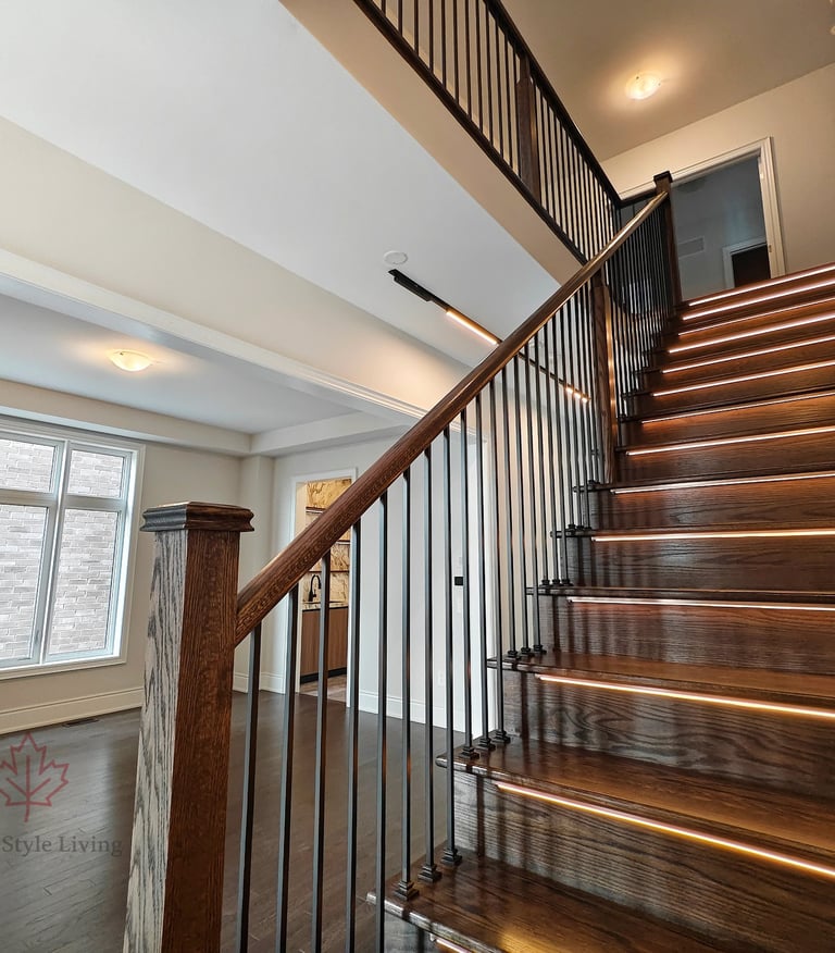 Architectural oak staircase with modern black railings and integrated linear step lighting in a high