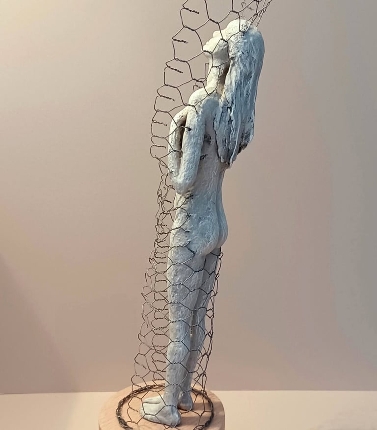 A standing female figure, leaning back and relaxing, surrounded by a wire netting enclosure