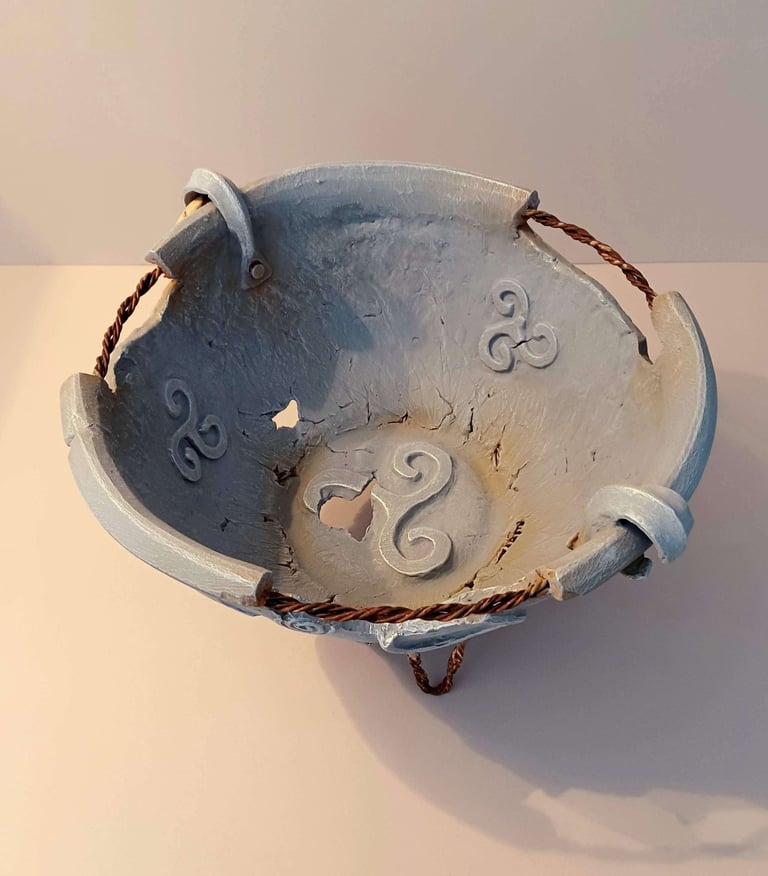 Interior of a round bowl-like sculpture with rusty wire, symbols and letters