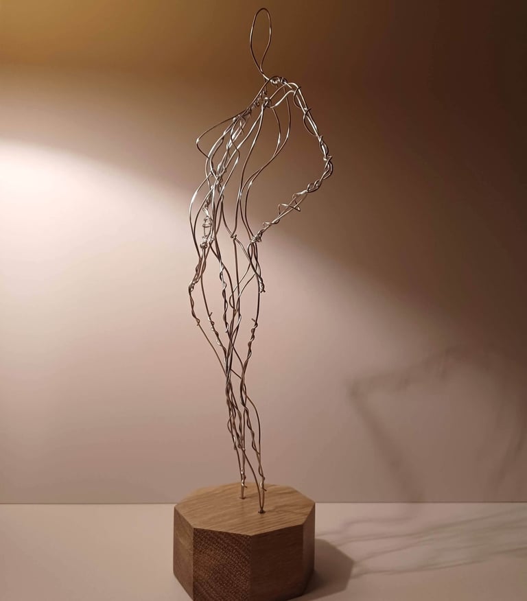 A wire sculpture of a complete female figure, standing with hands on hips