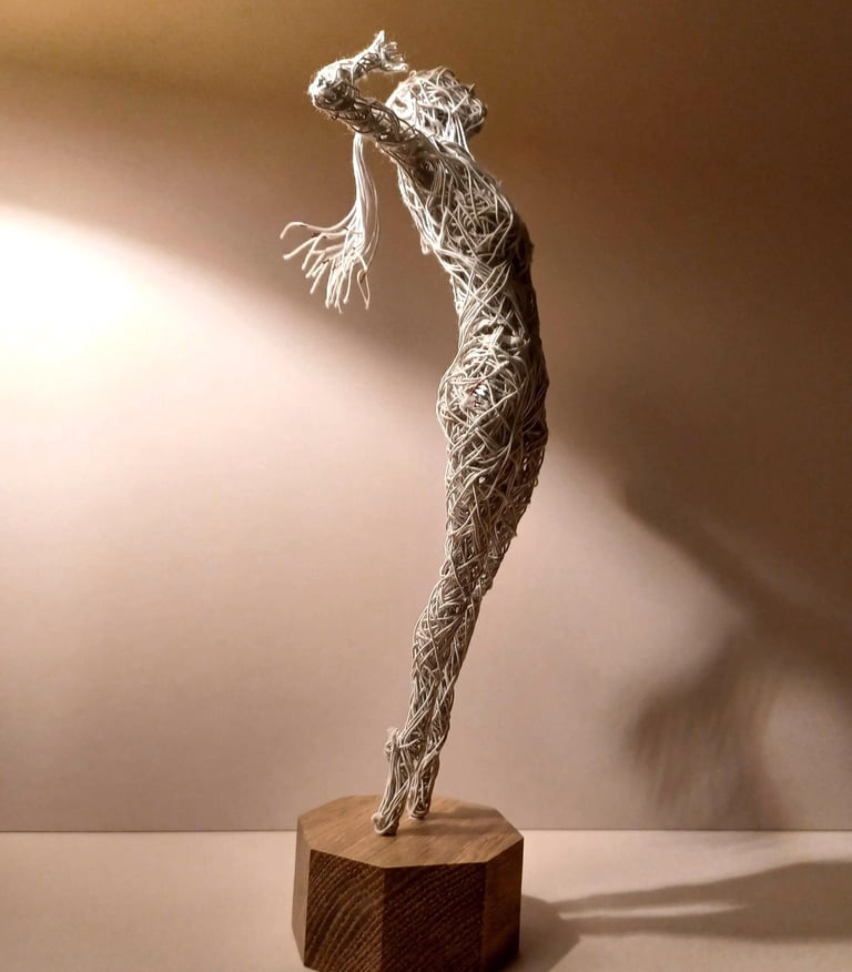 A cotton-covered wire sculpture of a standing female figure stretching with arms raised