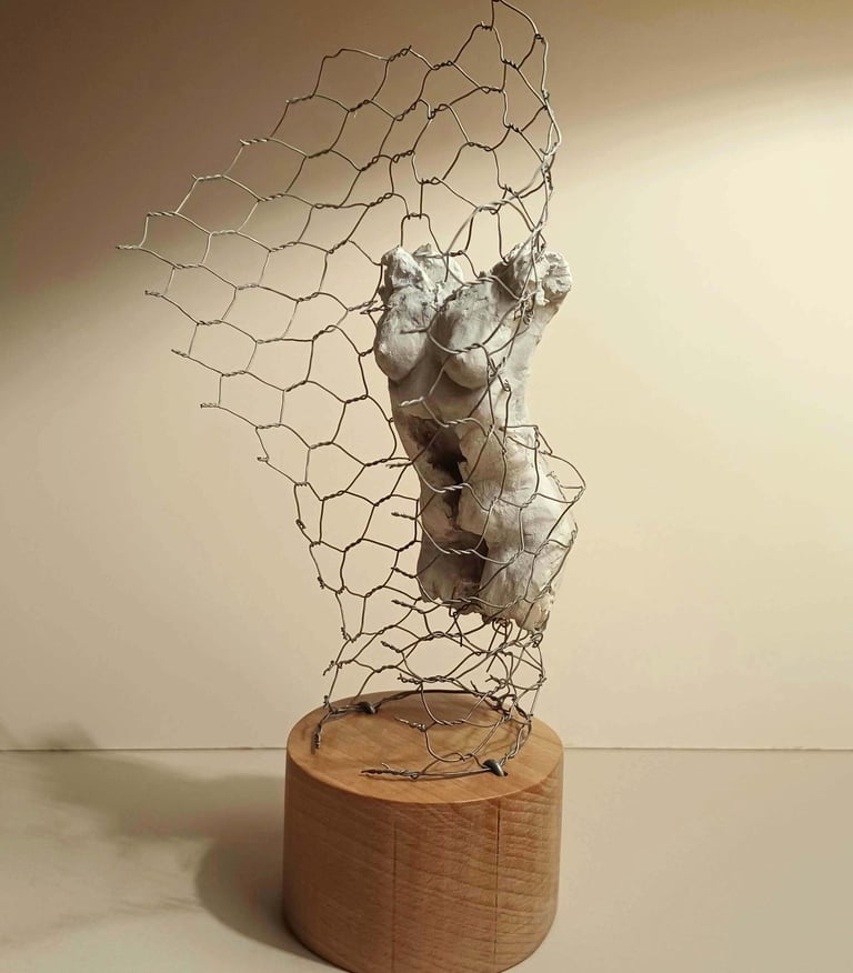 A clay female torso surrounded by wire netting, painted in neutral colours