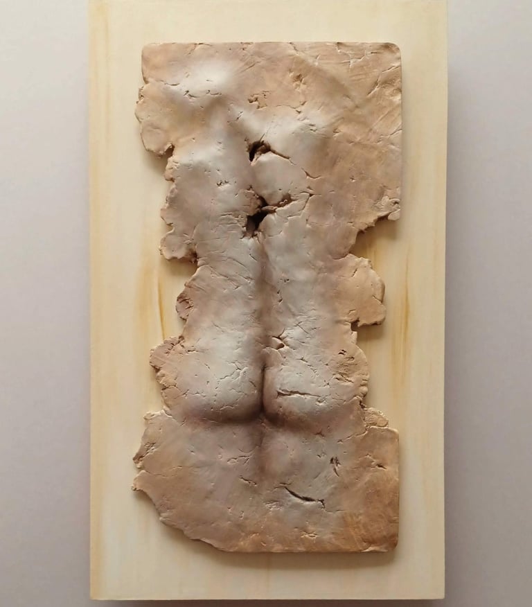 A relief sculpture of a fragmented female (rear view), painted warm browns