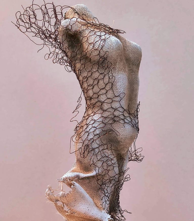 Close up of a female torso, clothed in tight fitting fabric, wrapped in torn copper wire netting