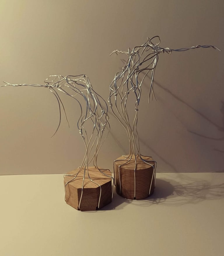 Two similar wire sculptures of complete female figures, standing, bending over backwards, arms out
