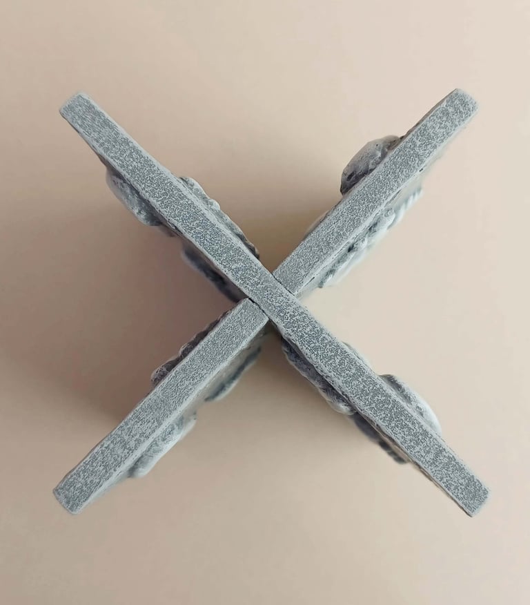 Two intersecting relief sculptures forming an X shape, and depicting three dimensional footprints.