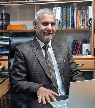 a man in a suit and tie sitting at a desk