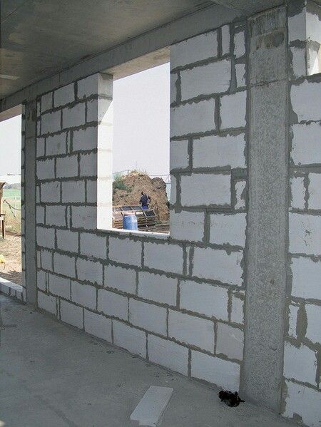 Mur porteur en blocs de béton cellulaire avec ouvertures pour fenêtres, en cours de construction dan
