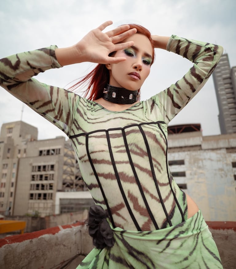 A stylish woman in a green tiger print bodysuit and spiked choker posing on an urban rooftop.