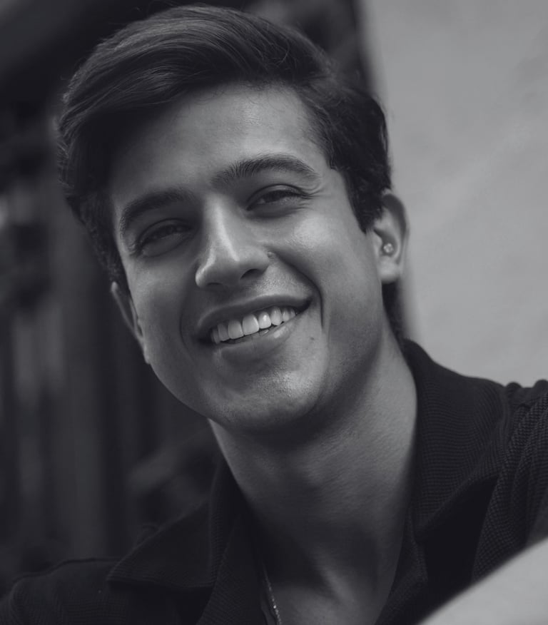 Man taking selfie with genuine smile while sitting, natural lighting with a friendly expression