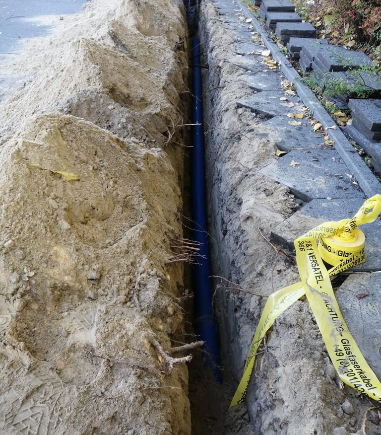 Baugrube mit Glasfaserleitung – UFT Bau GmbH Tiefbau Glasfaserausbau Berlin