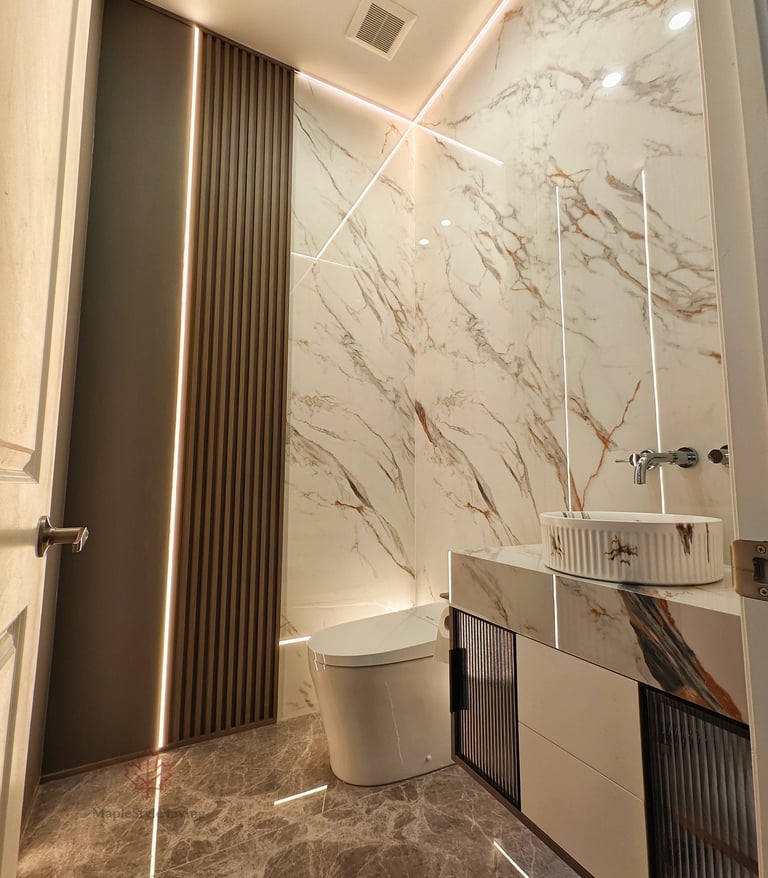 Sleek bathroom interior with seamless marble wall slabs, brushed gold metal trim accents, and a smar