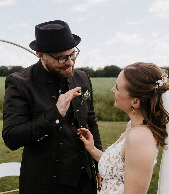 das alternative Hochzeitspaar strahlt sich nach dem Einzug an. der Bräutigam zeigt ihr, wie toll er ihren Style findet