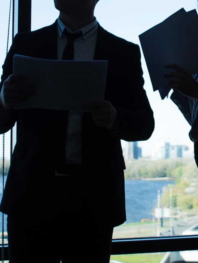 a group of people standing in front of a window discussing solution for client