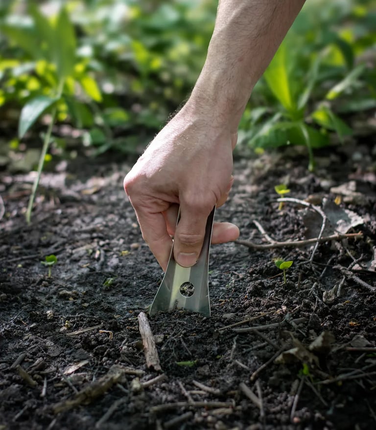 Hand pushing boglerco trowel into ground