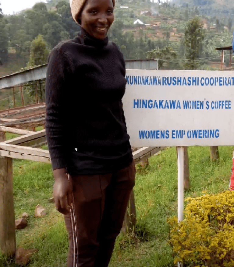 a woman standing in front of a sign that says, women"s coffee famers