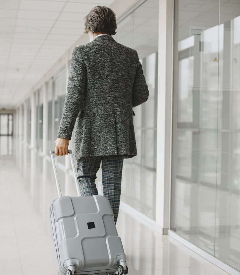 Executive pulling wheeled laptop bag through luxury hotel lobby