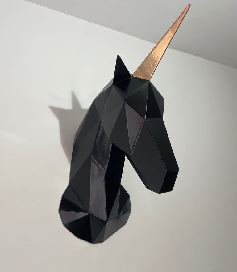 a black and gold unicorn headpiece with a gold horn horn