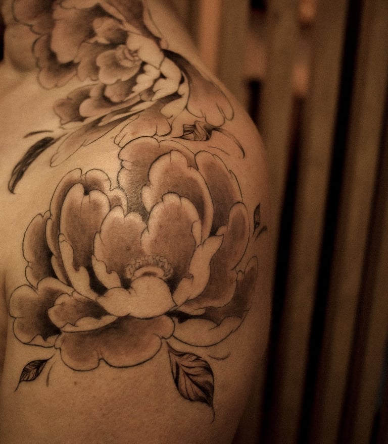pivoines japonaises tatouées sur l'épaule d'une cliente de Minuit Tattoo