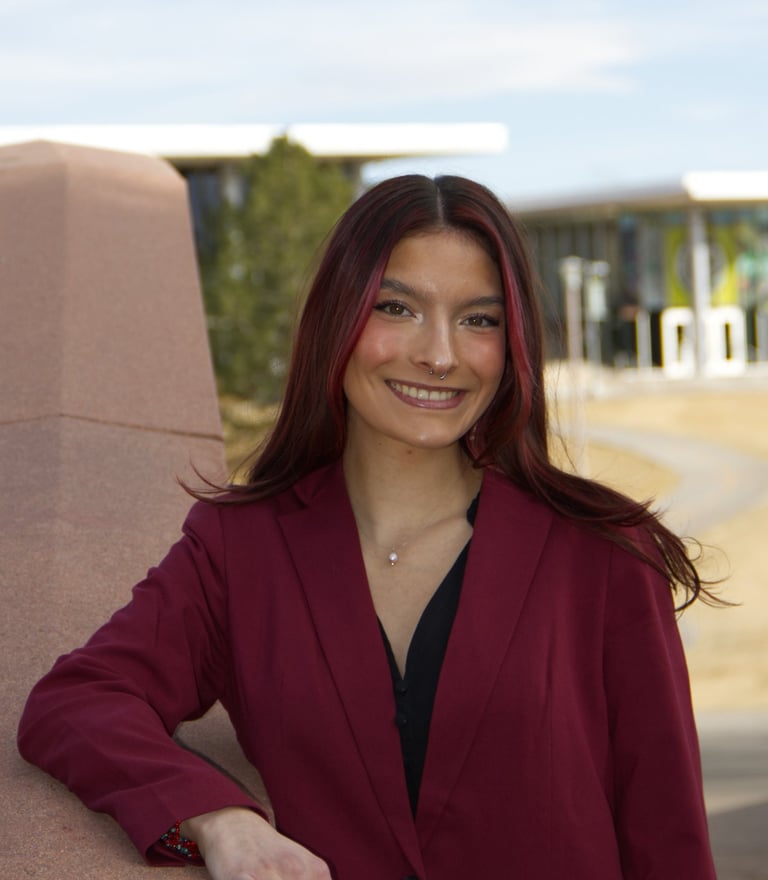 Image of Quesada-Stoner in a maroon suit 