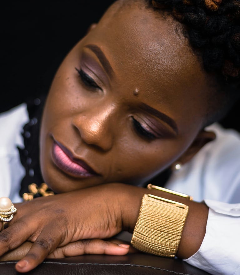 A Black woman resting peacefully with her head on her arm, symbolizing sacred rest....