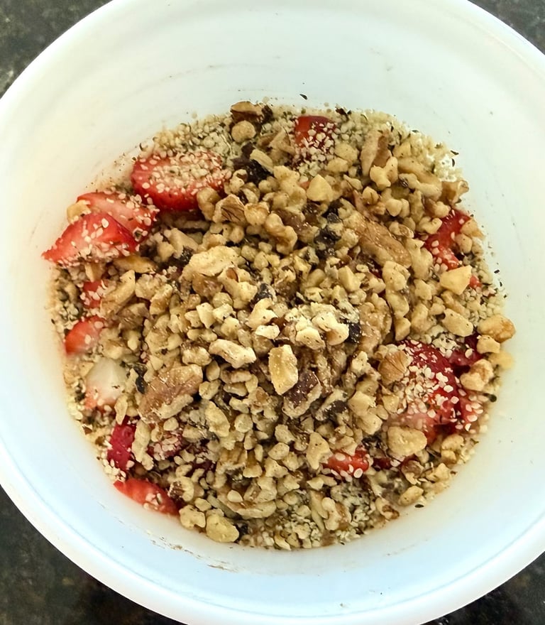 High protein oatmeal bowl topped with walnuts, hemp hearts, and strawberries.
