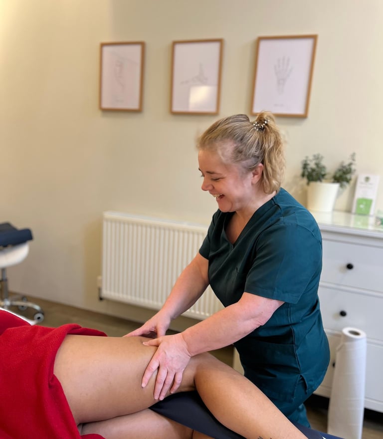 female massage therapist delivering sports massage to patient in clinic