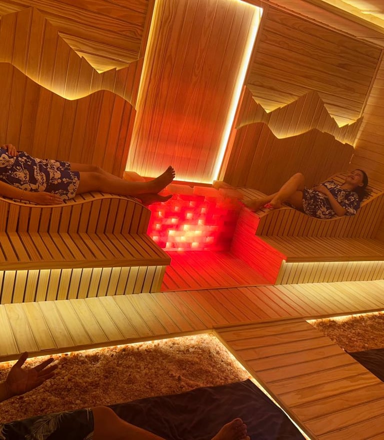 woman and man are sitting in a wooden hot stone sauna