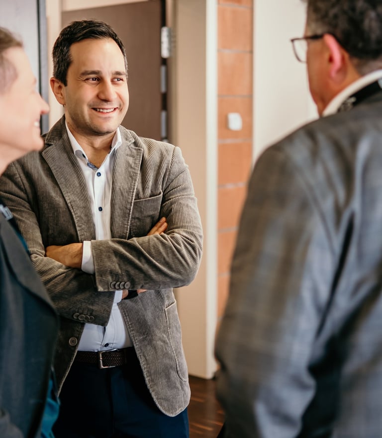 Smiling professionals in business casual attire networking at a corporate office event.