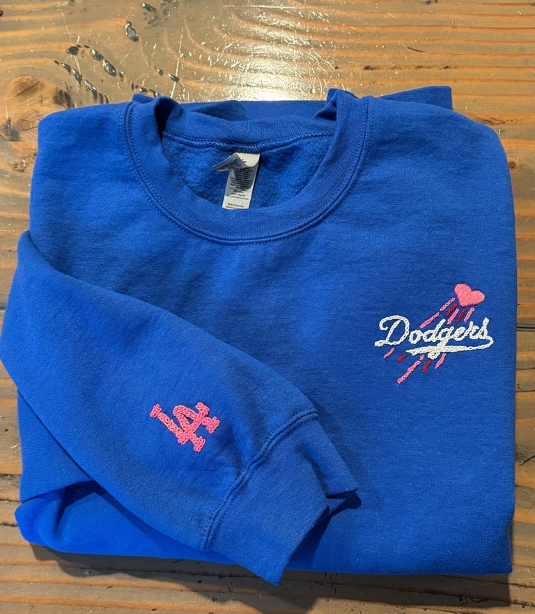 a blue sweatshirt with the dodgers logo on it