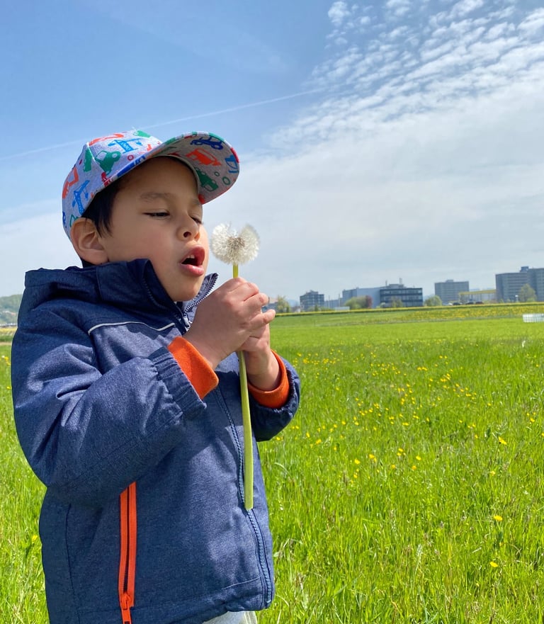 a young boy in a blue jacket and a hat