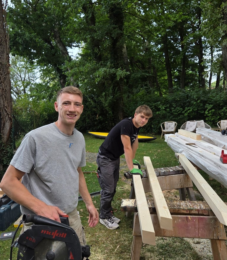 Gut gelaunte Azubis von Holztechnik Volk bei Holzarbeiten im Garten am Ammersee.