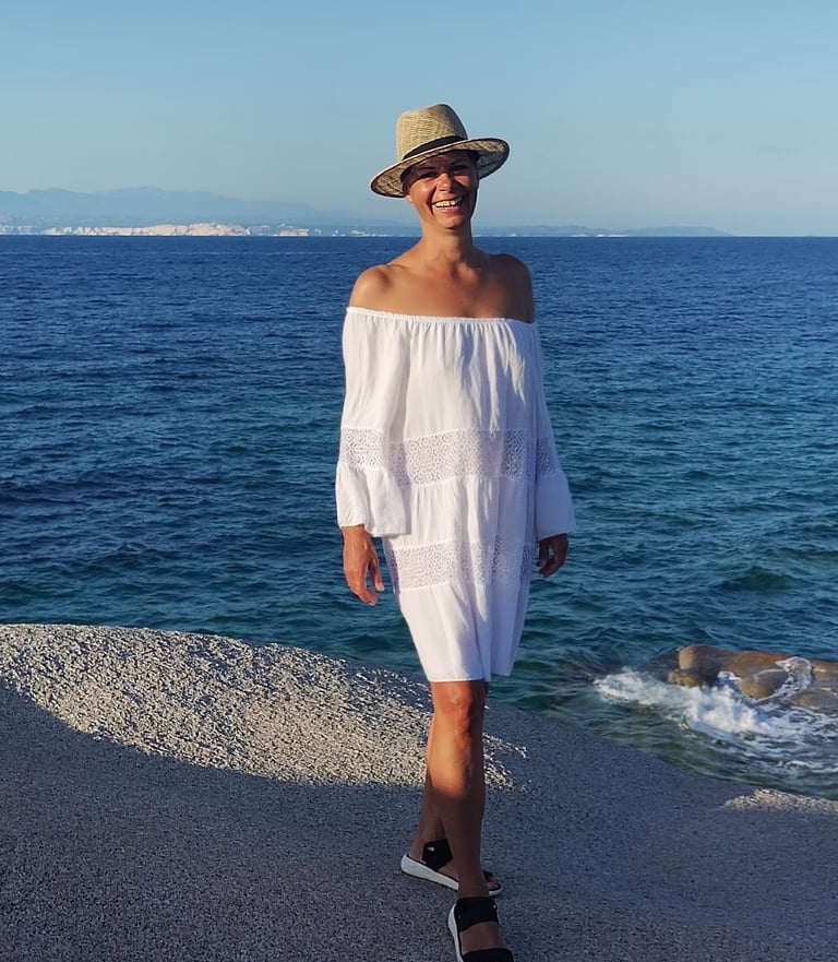 Stephanie Kabelin am Strand mit Hut und weißem Kleid