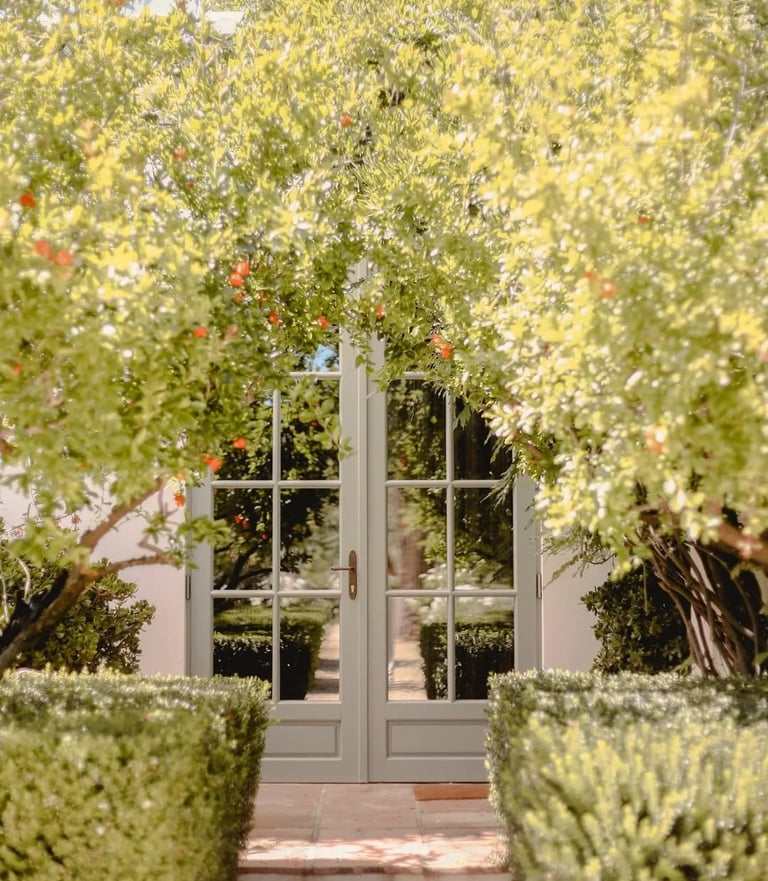 Garden entrance with glass doors framed by flowering trees