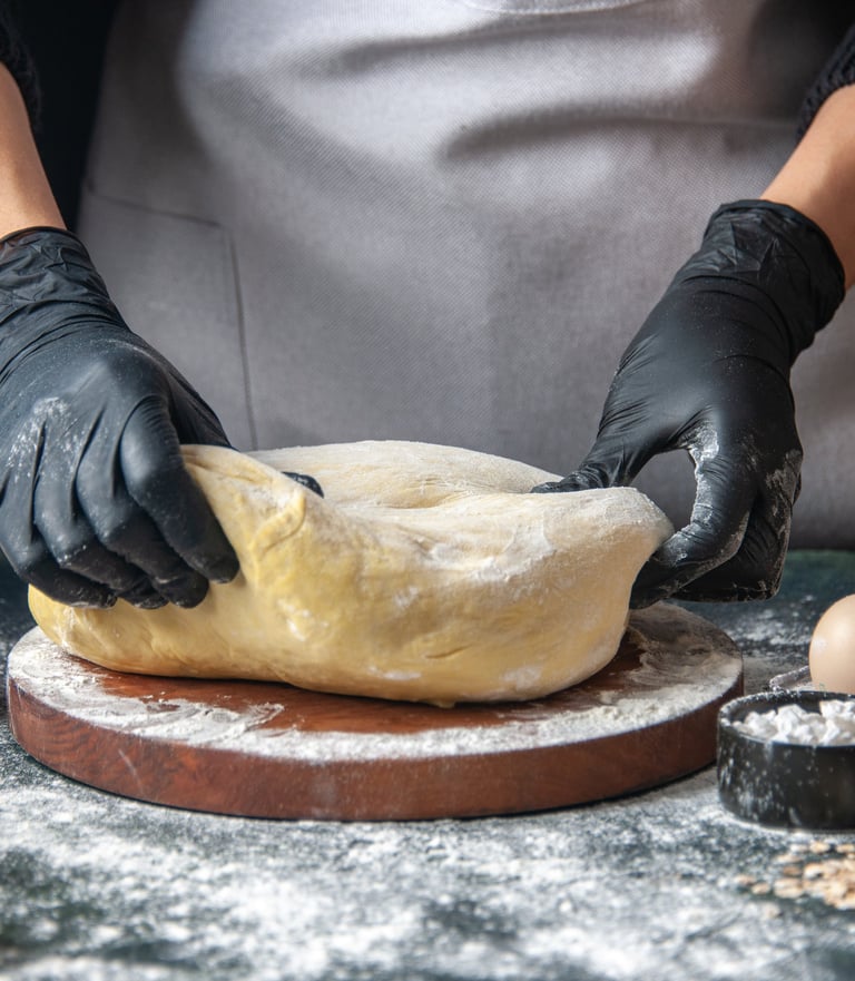 a person wearing gloves and gloves while making a doughnut