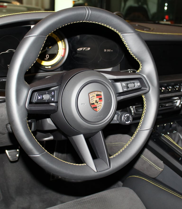 Porsche 911 GT3 steering wheel trimmed in black with "racing yellow" stitching